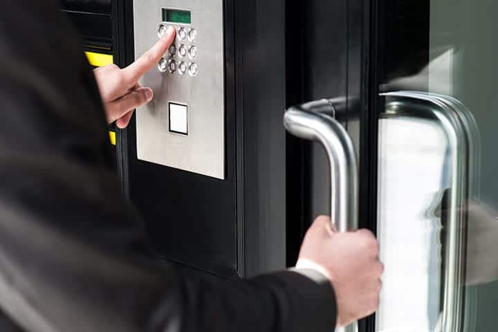 Man entering code in keypad to unlock security door